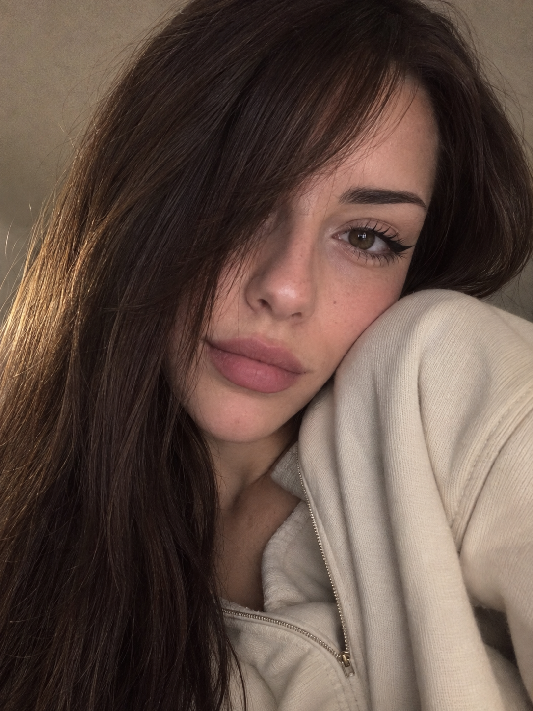 Portrait selfie réaliste en gros plan d'une femme adulte en sweat à capuche crème